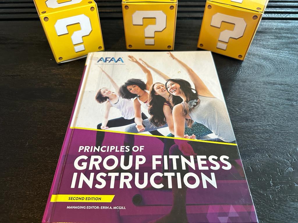 How to pick the best group fitness certification (Updated) 32 best training certifications - afaa group fitness textbook on table with yellow question mark boxes