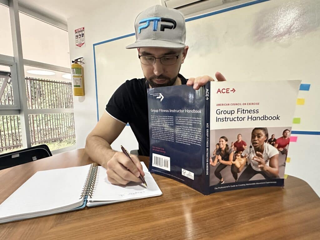 The Ultimate ACE Group Fitness Instructor Review 18 ace group fitness instructor review - Tyler read holds up ace gfi handbook while taking test - how hard is the ace exam