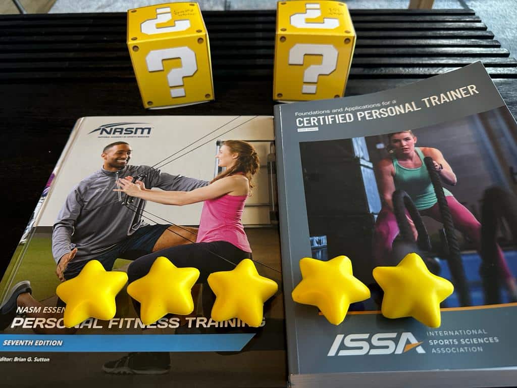 Comparing NASM and ISSA: Which Certification is Right for You? 60 NASM vs ISSA - textbooks for NASM and ISSA on table with stars and yellow question mark boxes - overall rating