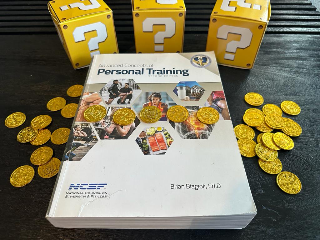Cheapest personal trainer certification guide (Updated) 33 cheapest personal training certification - NCSF textbook laid out on table with gold coins and mystery boxes - how much does NCSF CPT cost?
