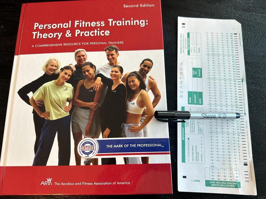 Easiest personal trainer certification guide (Updated) 50 Personal training certifications - AFAA CPT textbook laid out with a copy of scantron exam next to it and a sharpie