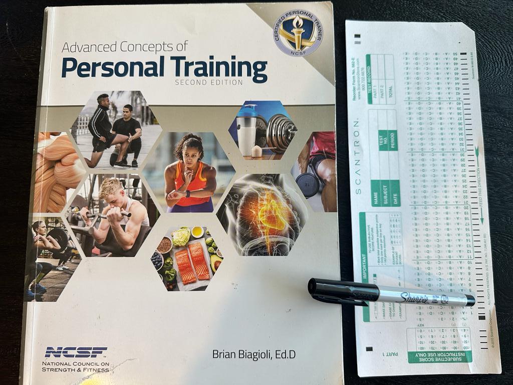 Easiest personal trainer certification guide (Updated) 40 Easy personal training certification - NCSF CPT textbook laid out with a copy of scantron exam next to it and a sharpie