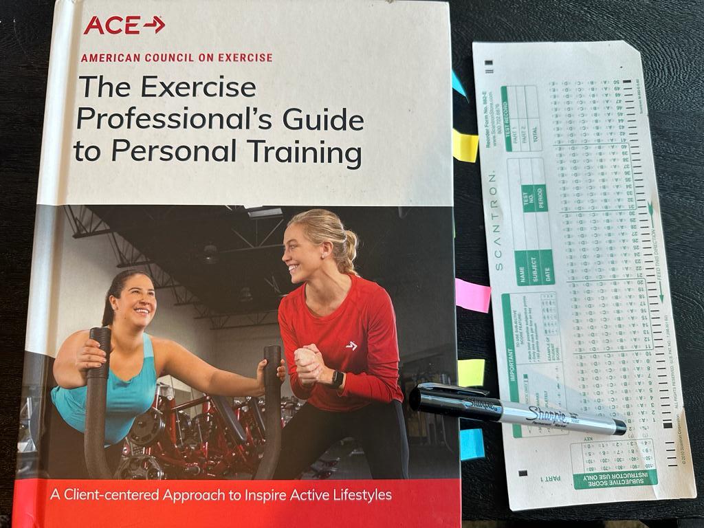 Easiest personal trainer certification guide (Updated) 48 Easiest personal trainer certification - ACE CPT textbook laid out with a copy of scantron exam next to it and a sharpie