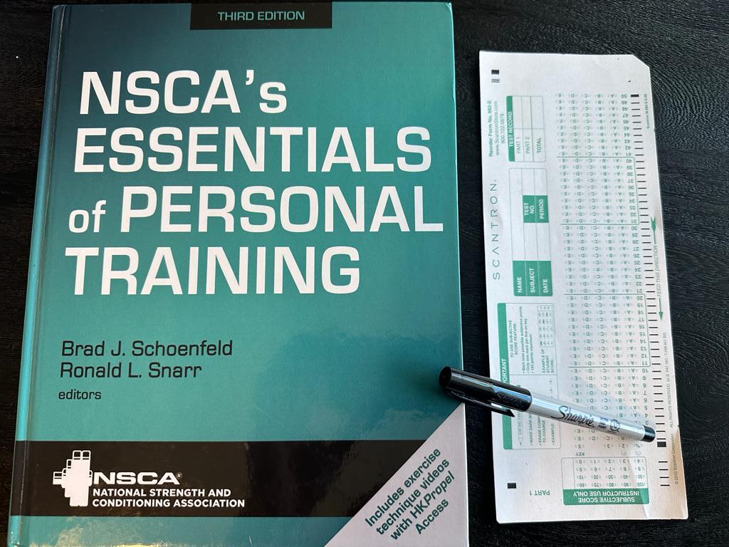Easiest personal trainer certification guide (Updated) 46 Easy personal training certification - NSCA CPT textbook laid out with a copy of scantron exam next to it and a sharpie
