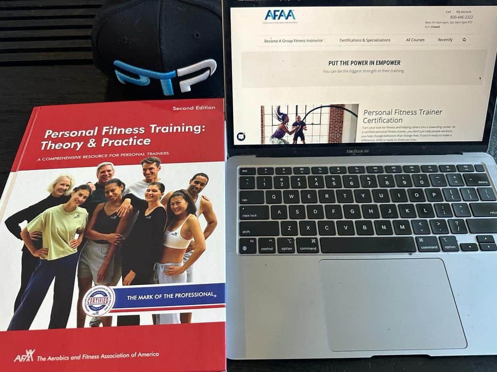 Best online personal trainer certification guide (Updated) 44 best online personal training certifications - afaa textbook next to laptop showing afaa website near ptp hat