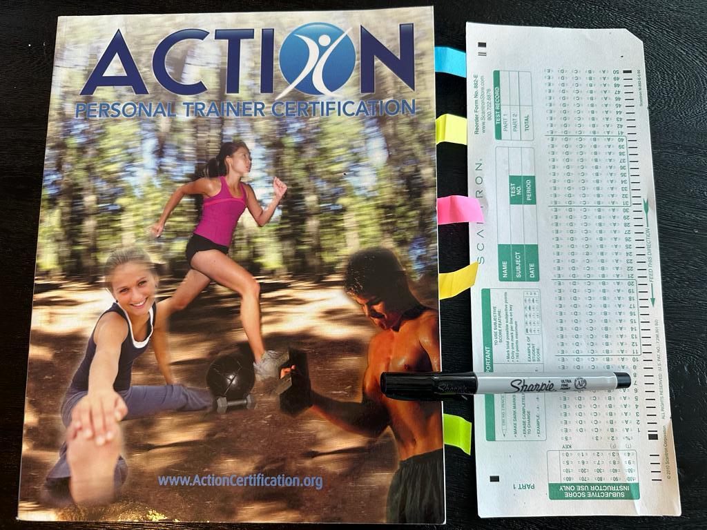 Easiest personal trainer certification guide (Updated) 38 Easiest personal trainer certifications - Action CPT textbook laid out with a copy of scantron exam next to it and a sharpie