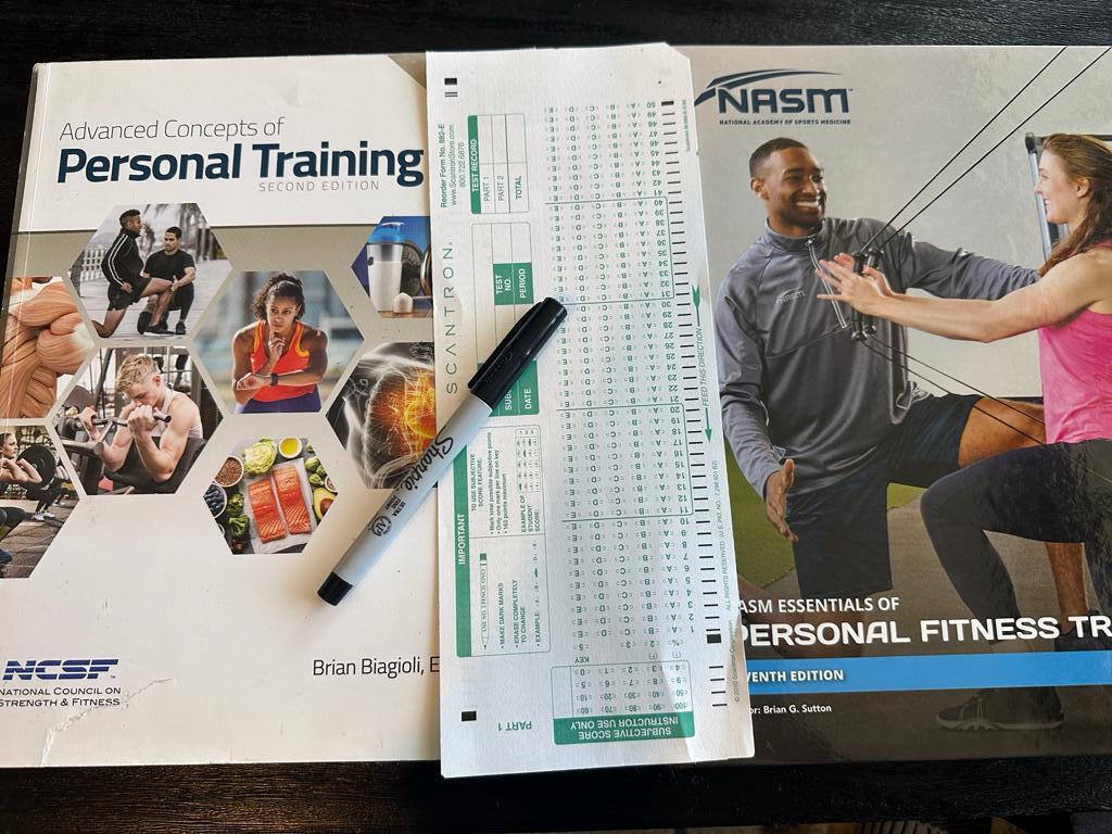 NASM vs NCSF - NCSF and NASM textbooks with scantron exam sheet and sharpie 