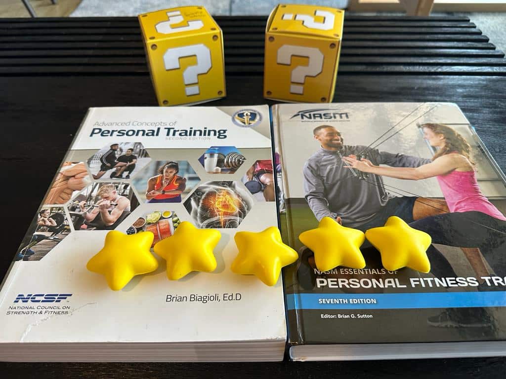 NASM vs NCSF - NASM and NCSF textbooks on table with yellow stars and question mark boxes