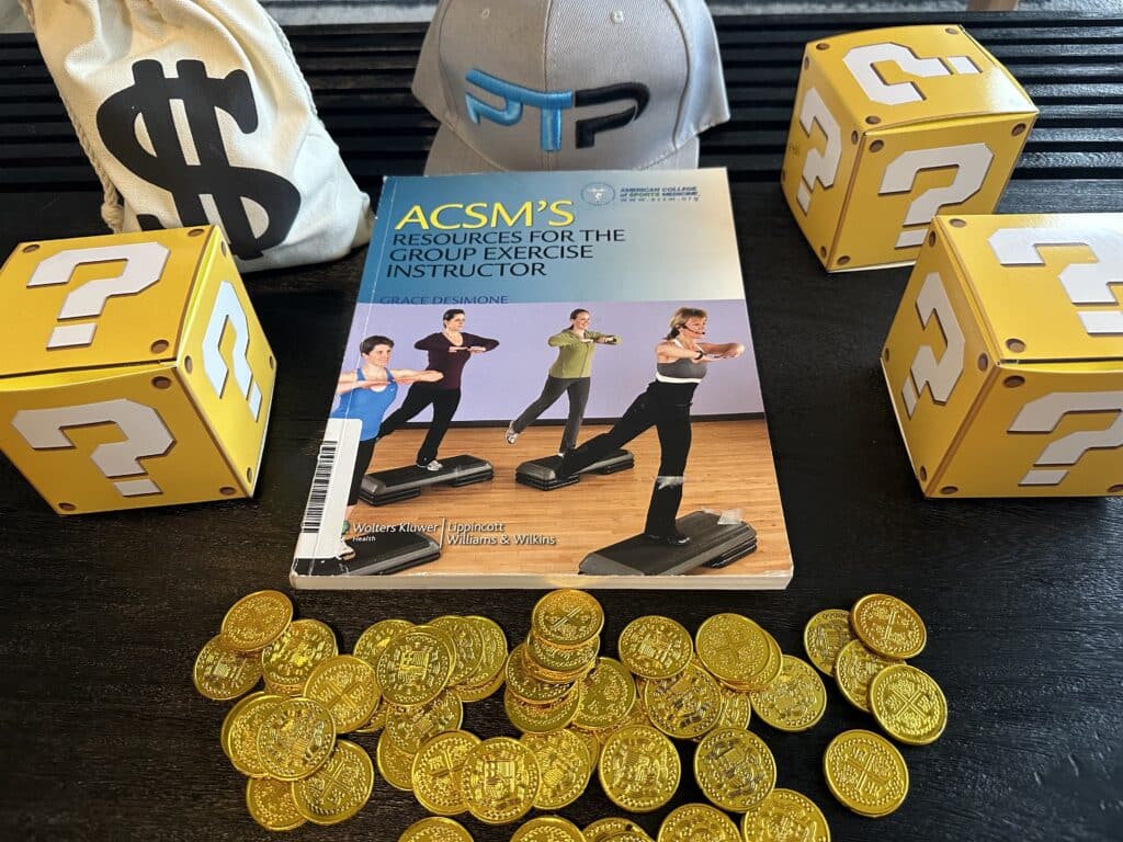ACSM Group Exercise Instructor (ACSM-GEI) Review 17 acsm group instructor cost. acsm group exercise textbook with gold coins on table.
