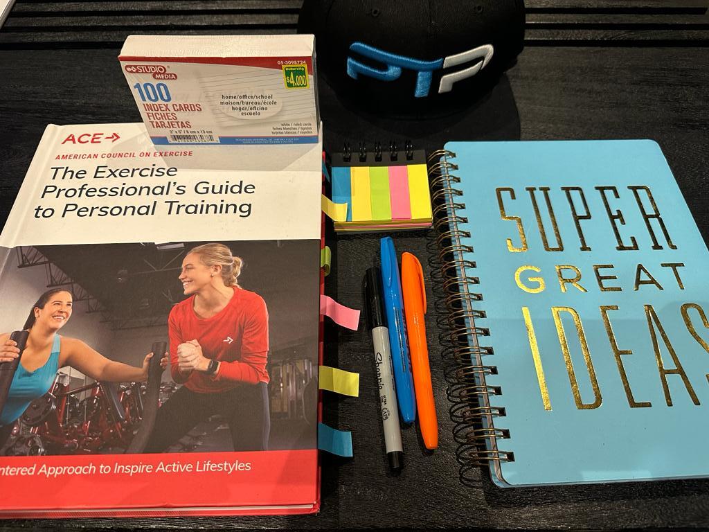 ACE Exam Prep - How to pass the ACE Exam On Your First Try 4 ACE CPT exam prep - ACE textbook laid on table with journal for taking notes in preparation for ACE exam prep.