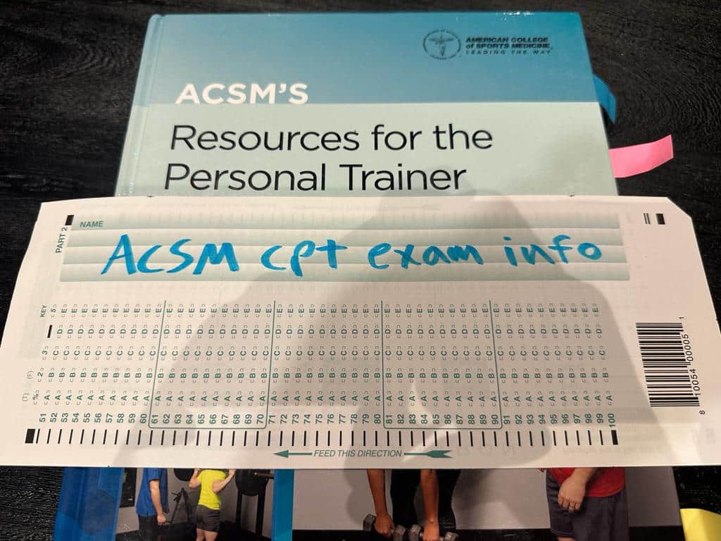ACSM Exam Info - Pass Rate, Costs, and More 11 ACSM CPT Exam Info - ACSM textbook placed on table with scantron sheet.