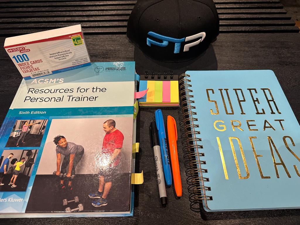 ACSM Exam Prep - How to Pass the ACSM Exam on the First Try 7 ACSM Exam Prep - ACSM textbook on table with journal for prepping for the final ACSM test.