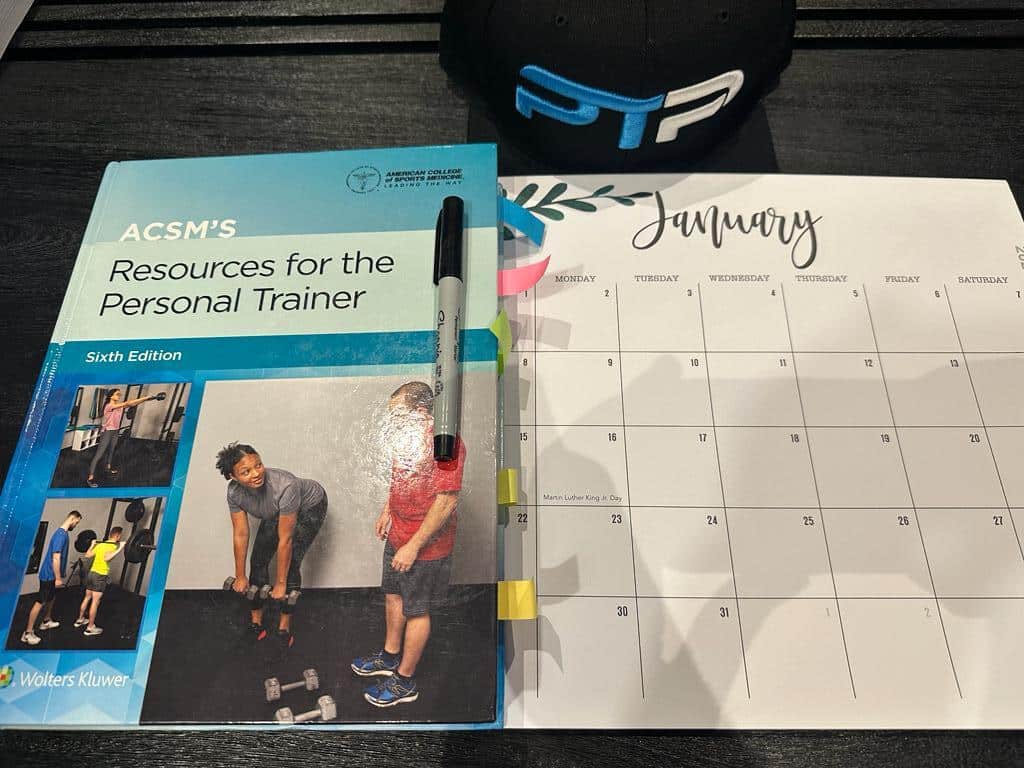 FREE ACSM Study Plan, Study Calendar + Blueprint 4 Free ACSM study plan - ACSM textbook on table with study calendar to plan out ACSM study sessions