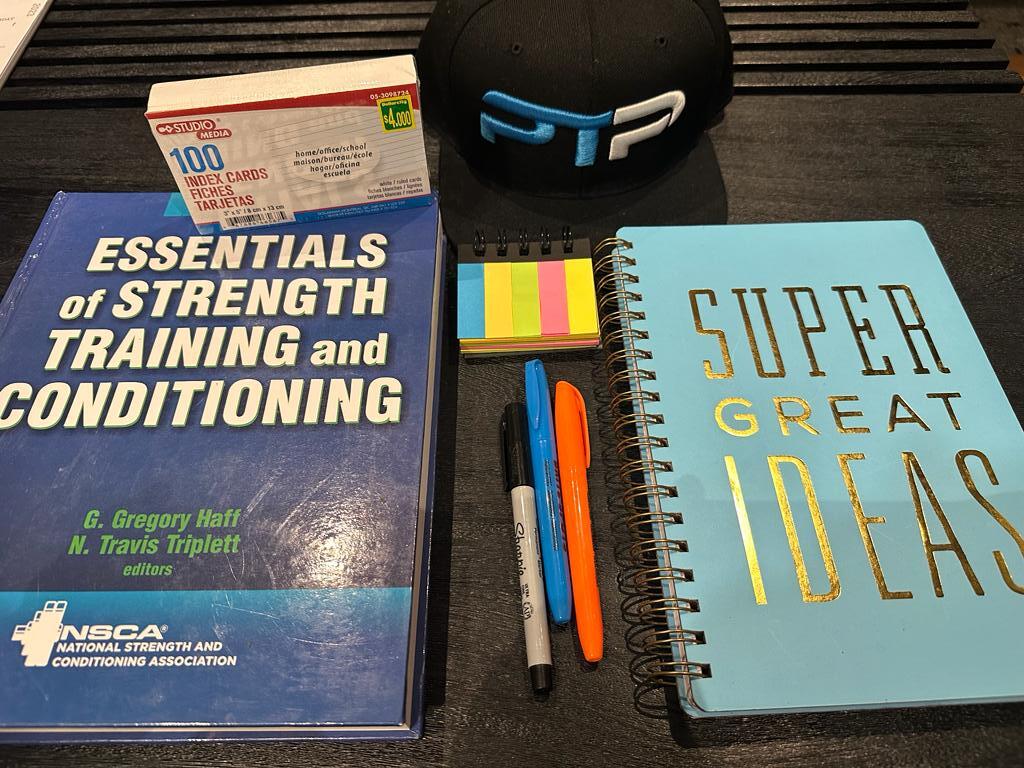 The Complete CSCS Exam Prep - How to Pass the CSCS Exam 6 Free CSCS exam prep. CSCS textbook laid out with a notebook to prep for the CSCS exam.