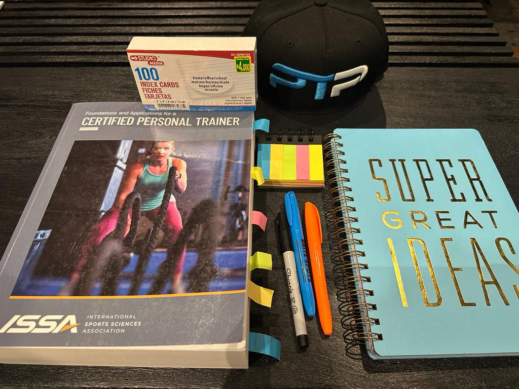 ISSA Exam Prep - How to pass the Exam On Your First Try 9 ISSA exam prep - ISSA textbook with notebook displayed on table for ISSA CPT exam prep