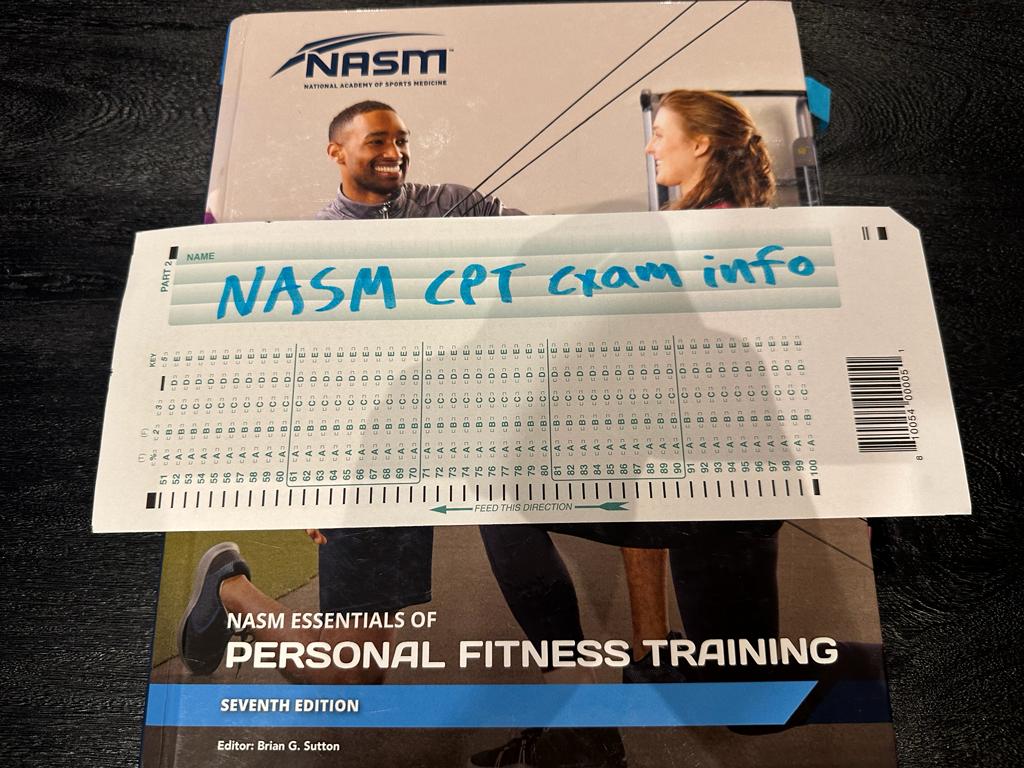 NASM CPT Exam Info - Pass Rate, Costs, and More 5 NASM CPT exam info - NASM textbook displayed on table with NASM exam info