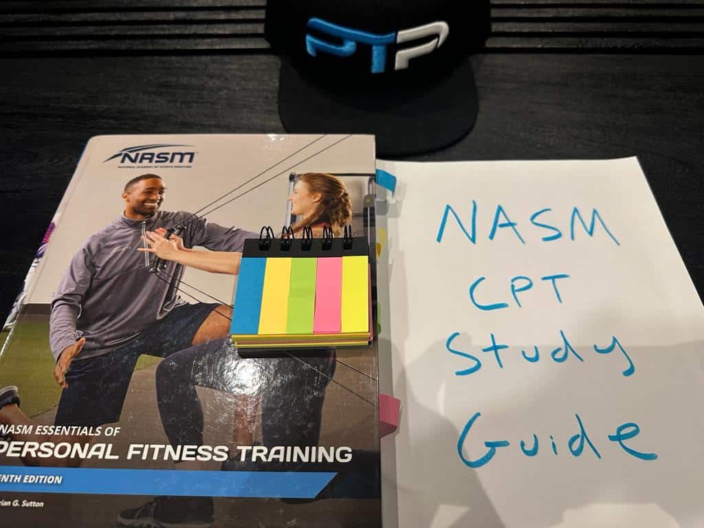Free NASM CPT Study Guide (all 23 chapters) 8 NASM CPT Study Guide - NASM Textbook on table with notes for studying the NASM personal trainer curriculum
