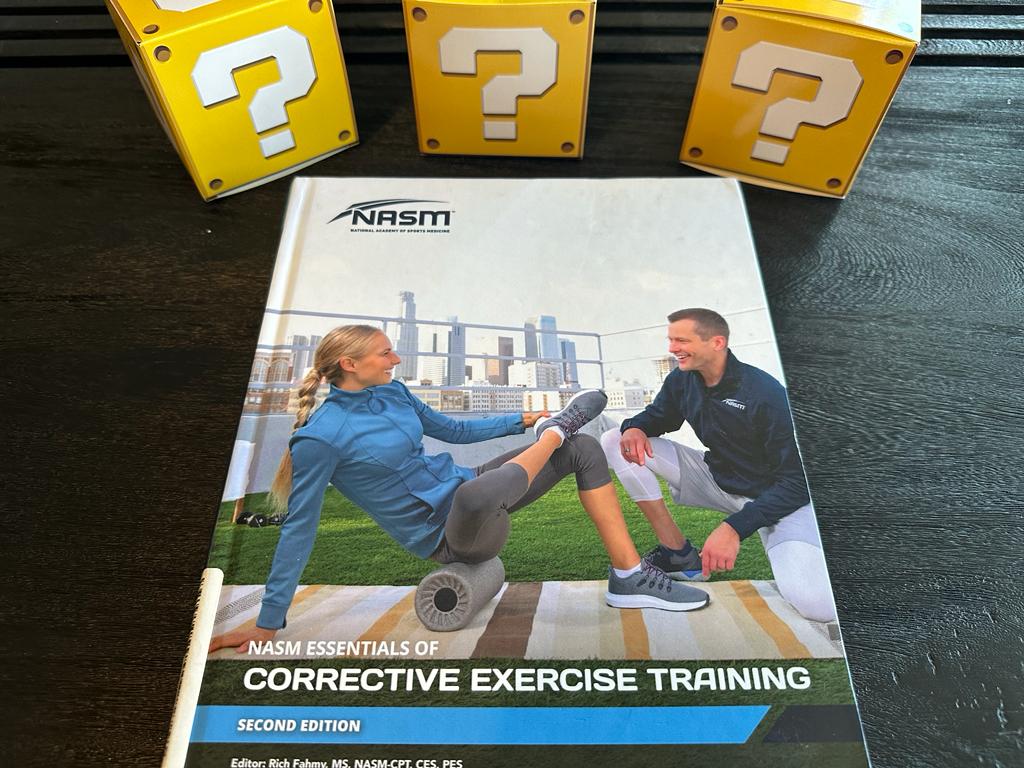 Best corrective exercise certification guide (Updated) 34 best corrective exercise training - nasm textbook on table with question mark boxes