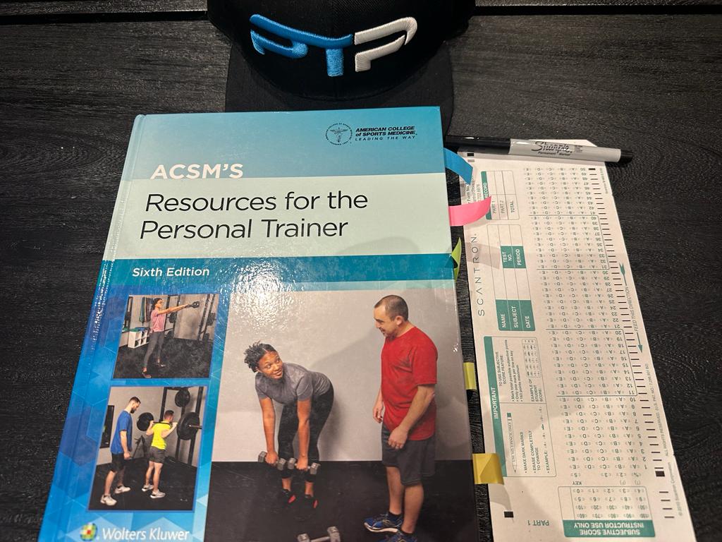 ACSM Practice Test – 240 Real Exam-Style Questions 19 ACSM practice tests - ACSM personal trainer textbook laid out on table with scantron sheet to take ACSM practice exam