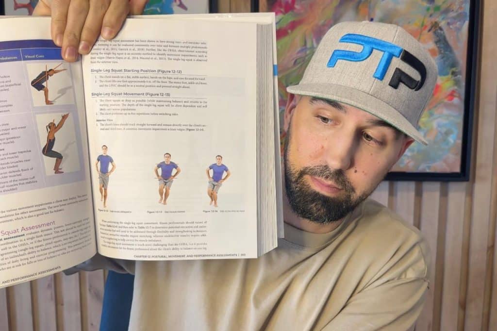 Tyler Read holds up NASM CPT textbook showing the single leg squat assessment