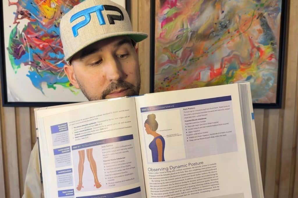 Tyler Read holds up NASM textbook showing Upper Crossed Syndrome