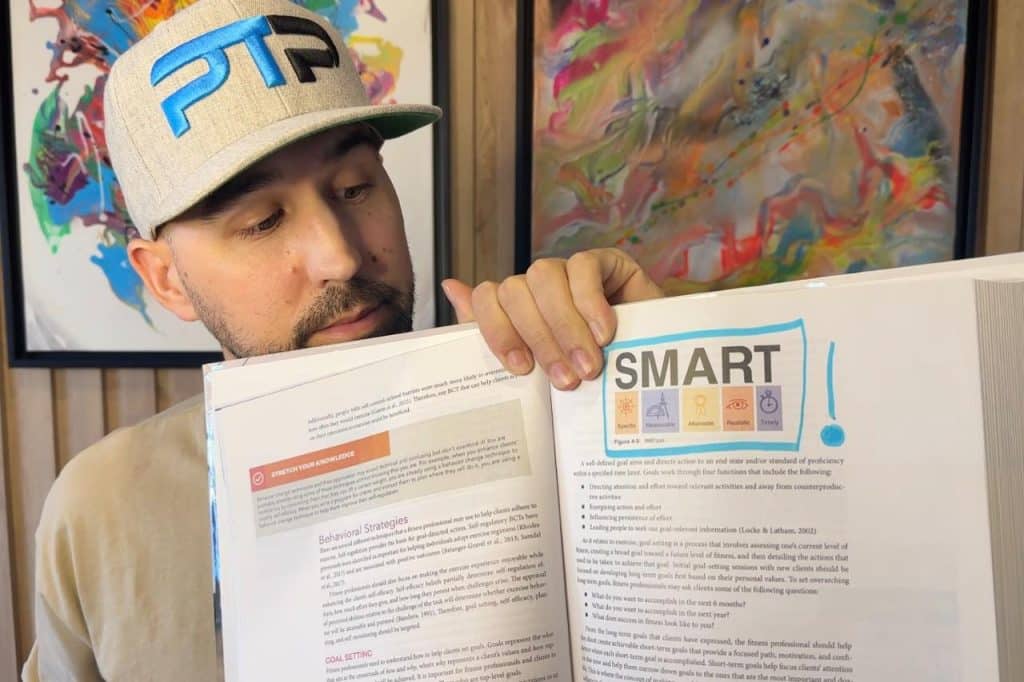 Tyler Read holds up page from NASM textbook on SMART goals
