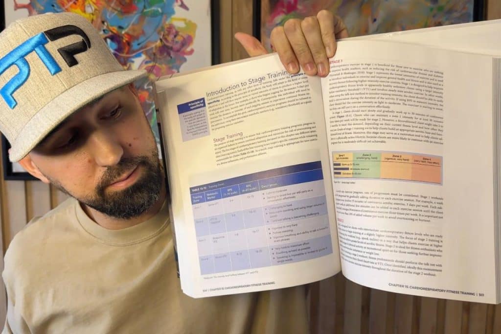 Tyler Read holds up NASM textbook to chapter on Heart Rate Zone training cardiovascular chapter 