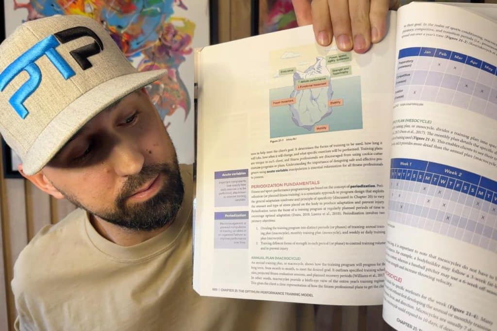 Tyler Read holds up NASM textbook looking at chapter on Periodization