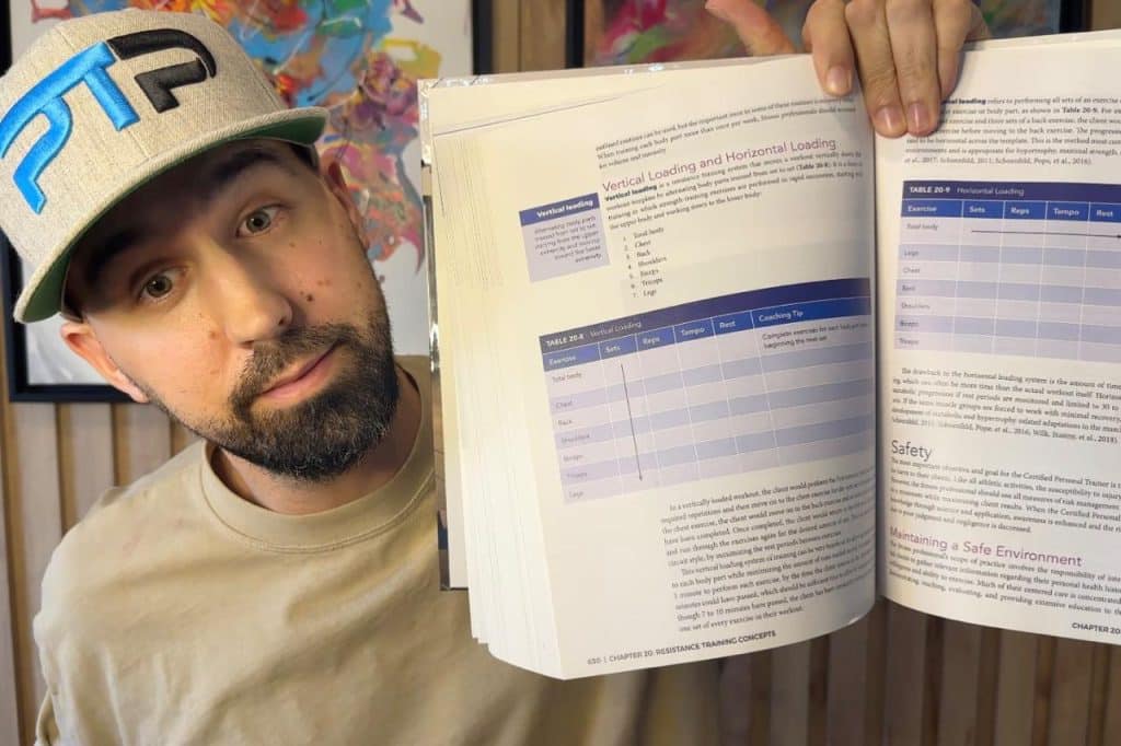 Tyler Read holding NASM textbook showing information on vertical and horizontal loading